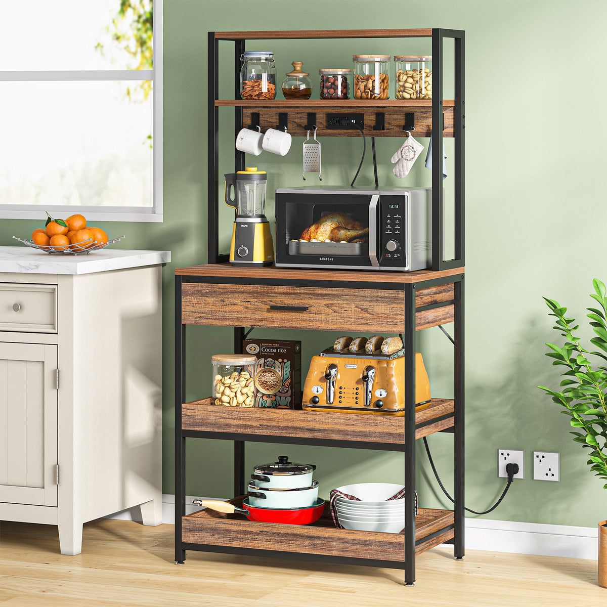 Stowena 5 tier bakers rack with power outlets holding a microwave and kitchen items beside a counter
