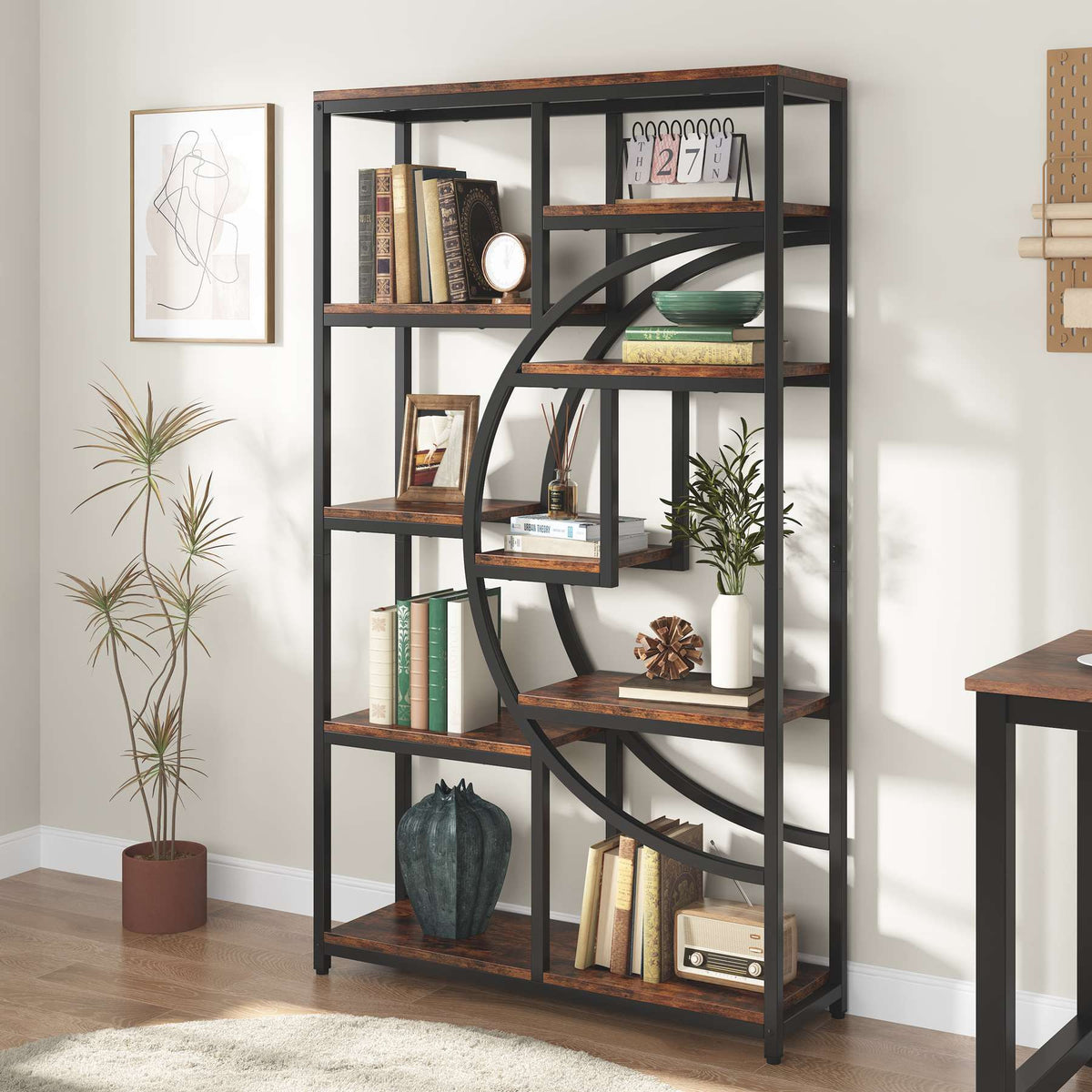 Etagere bookcase holding books, plants and decor against a pale wall