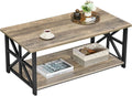 Gray wash farmhouse coffee table with X shaped black legs holding a tray, cup and plant