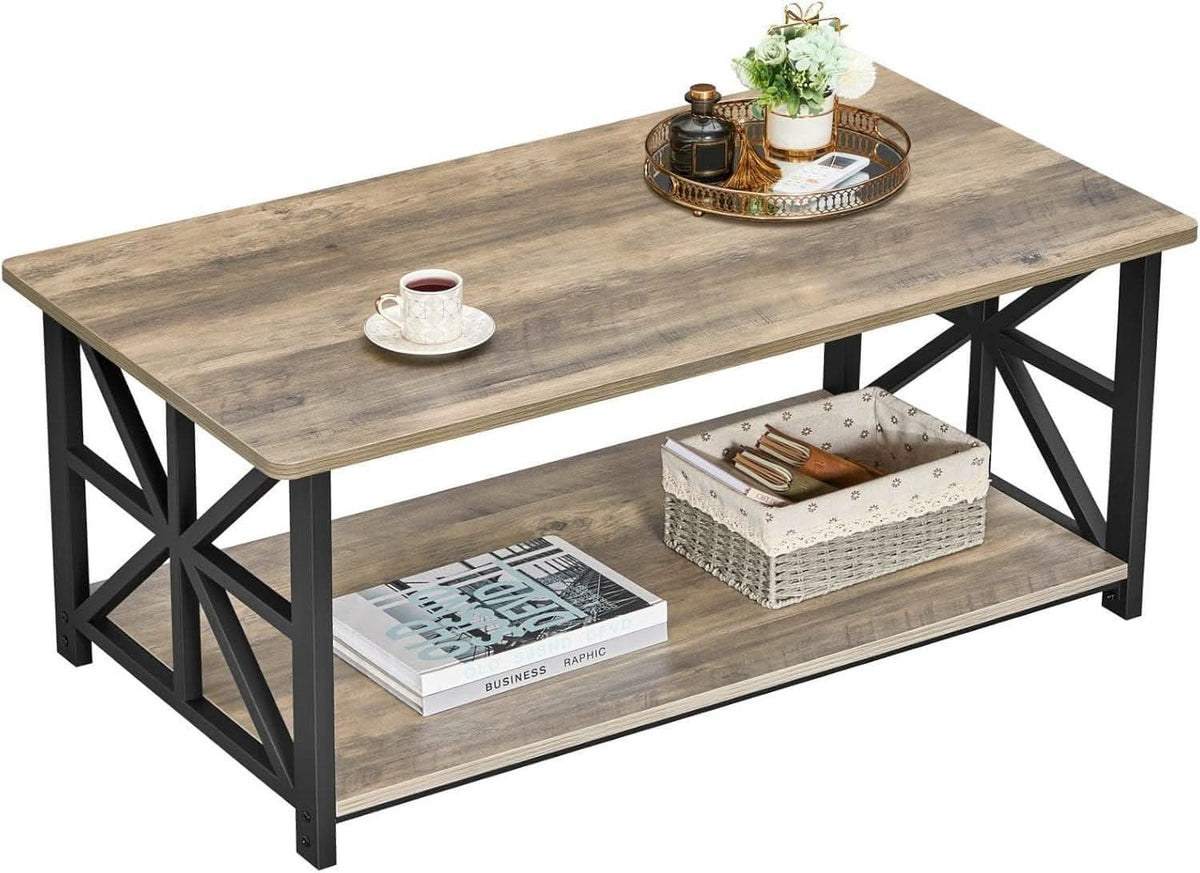 Gray wash farmhouse coffee table with X shaped black legs holding a tray, cup and plant