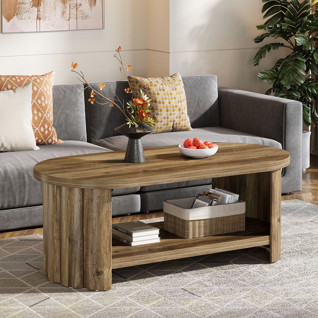 Oval two tier coffee table centered between a gray sectional and the TV wall