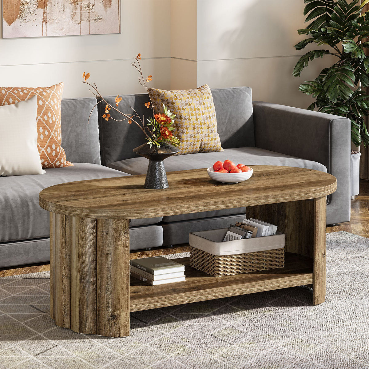 Oval two tier coffee table centered between a gray sectional and the TV wall