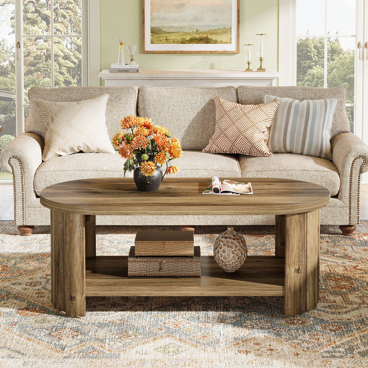 Brown oval coffee table with flowers and books in a farmhouse living room