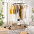 The chrome clothes rack in a bedroom holding dresses and shirts, with folded linens and baskets on the wire shelf underneath