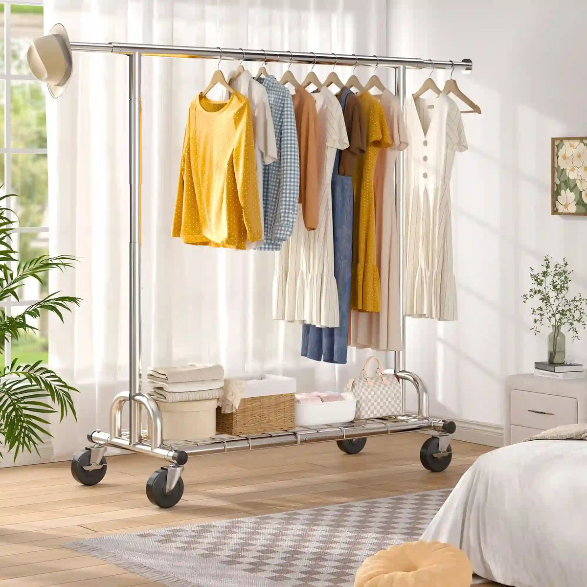 The chrome clothes rack in a bedroom holding dresses and shirts, with folded linens and baskets on the wire shelf underneath