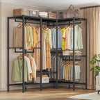 Black heavy duty clothes rack 76 x 18 x 77 in against a bedroom wall, seven rods holding shirts and dresses with folded stacks and baskets on the wire shelves