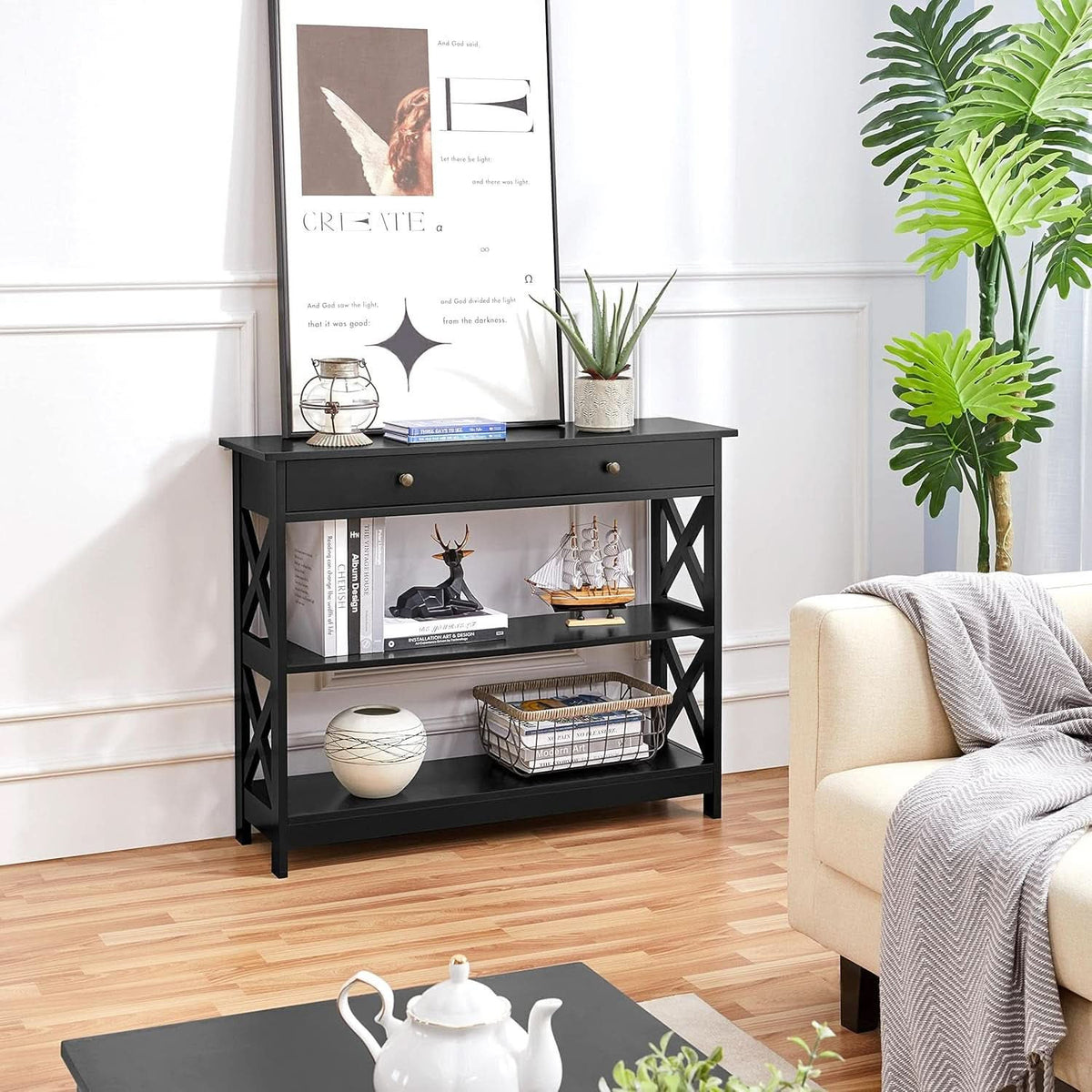 Narrow black sofa table with storage shelves beside a sofa