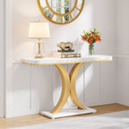 Faux marble console under a round gold mirror with a lamp and flowers on the tabletop
