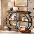 Brown three tier console table in a hallway with a lamp, books and baskets across its shelves