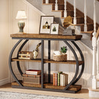 The table under a staircase with framed photographs and a lamp on the tabletop