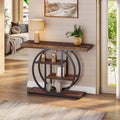Rustic brown console table with interlocking circle base in an entry, lamp and plant on top