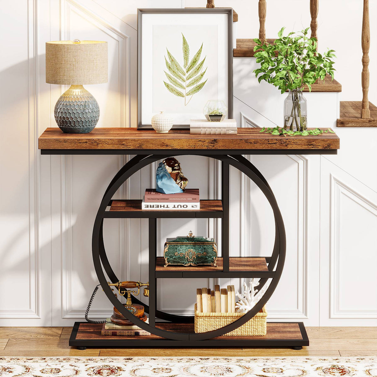 Console table with the circle frame holding books, a framed picture and plants