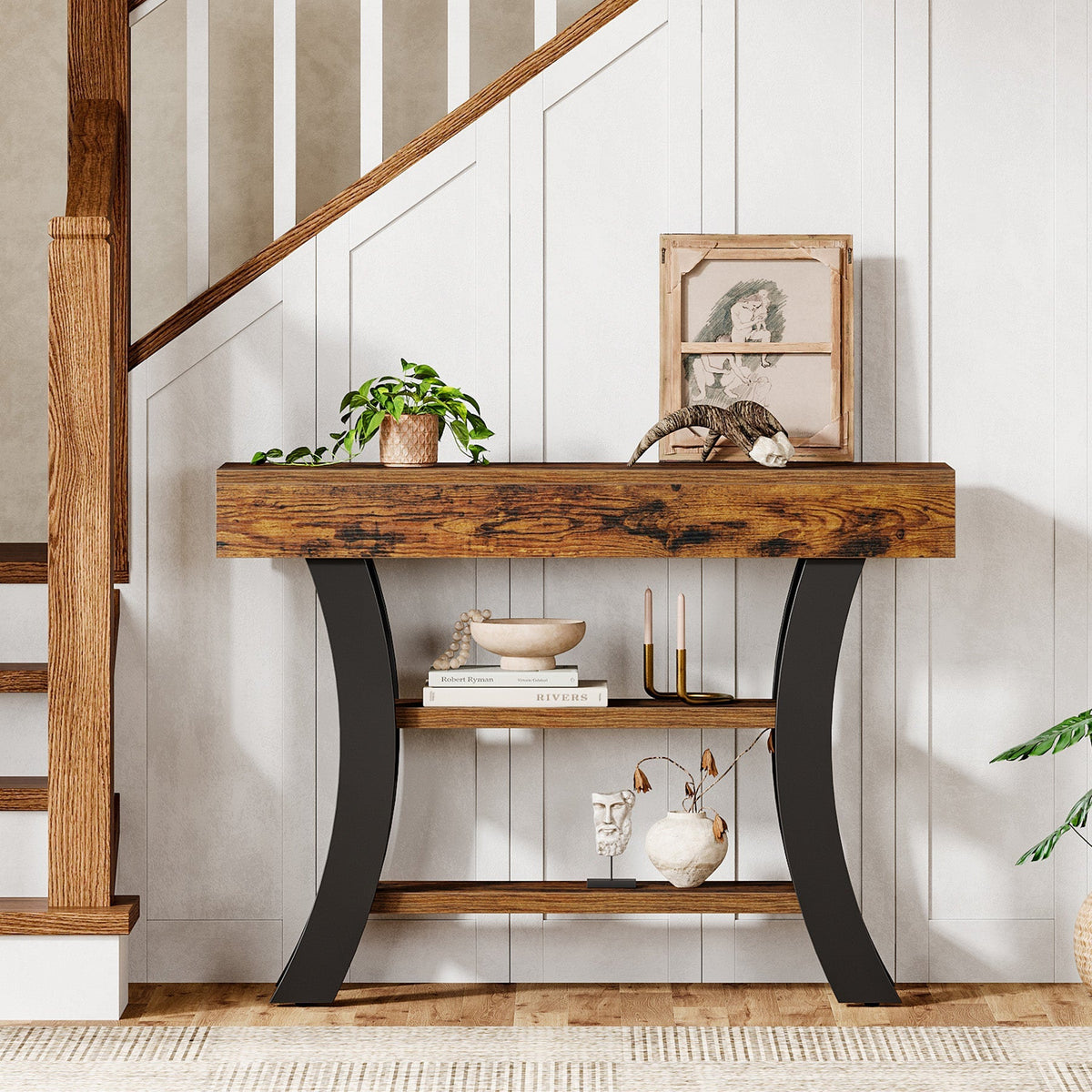 Curved entryway table styled by a staircase