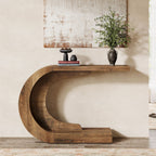 C shaped table under a large framed artwork with a plant and a small dish on top