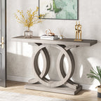 Gray console table in a hallway with a vase, books and a reed diffuser