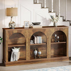 Arched farmhouse console table styled by a staircase with a lamp and baskets