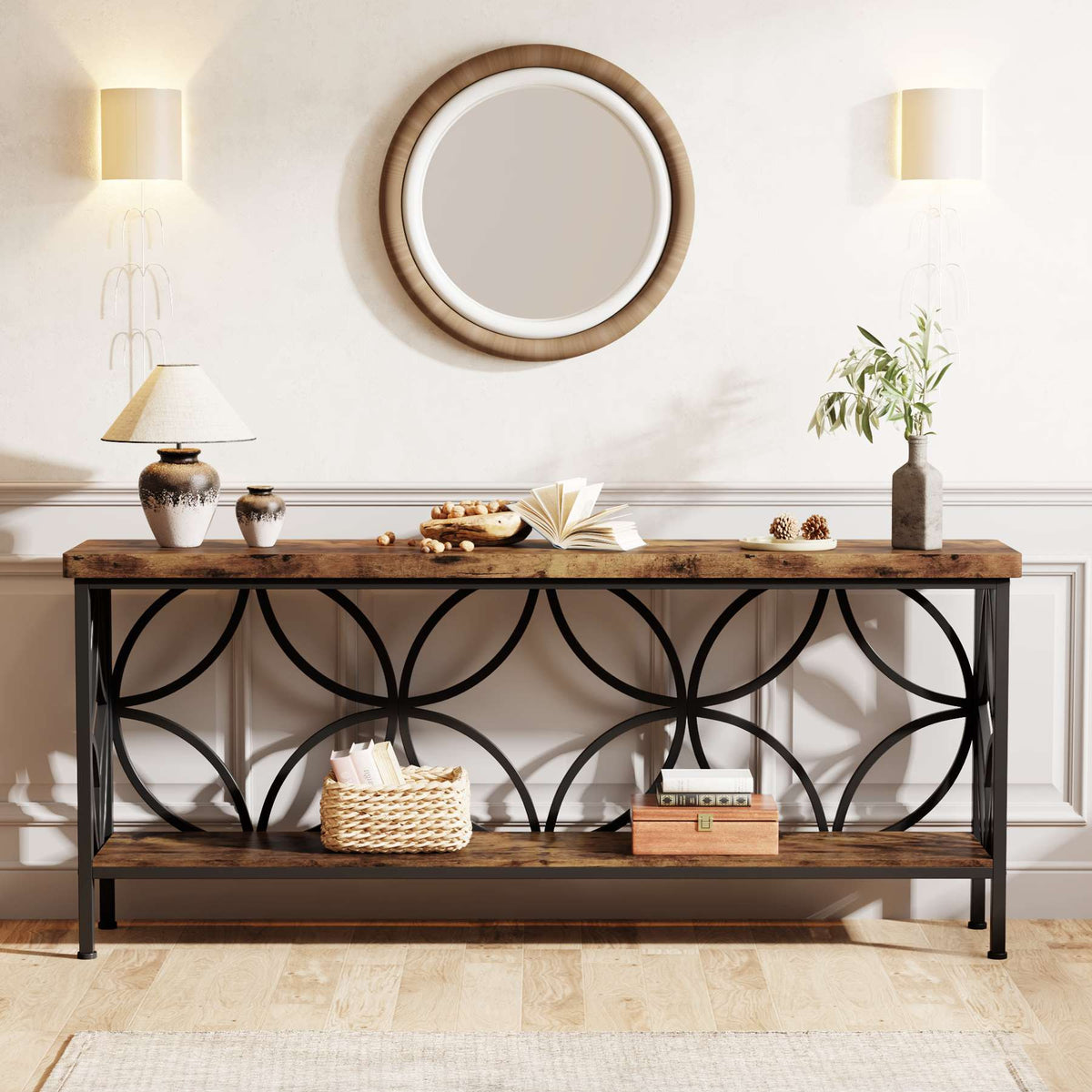 Industrial sofa table styled under a round mirror with lamps