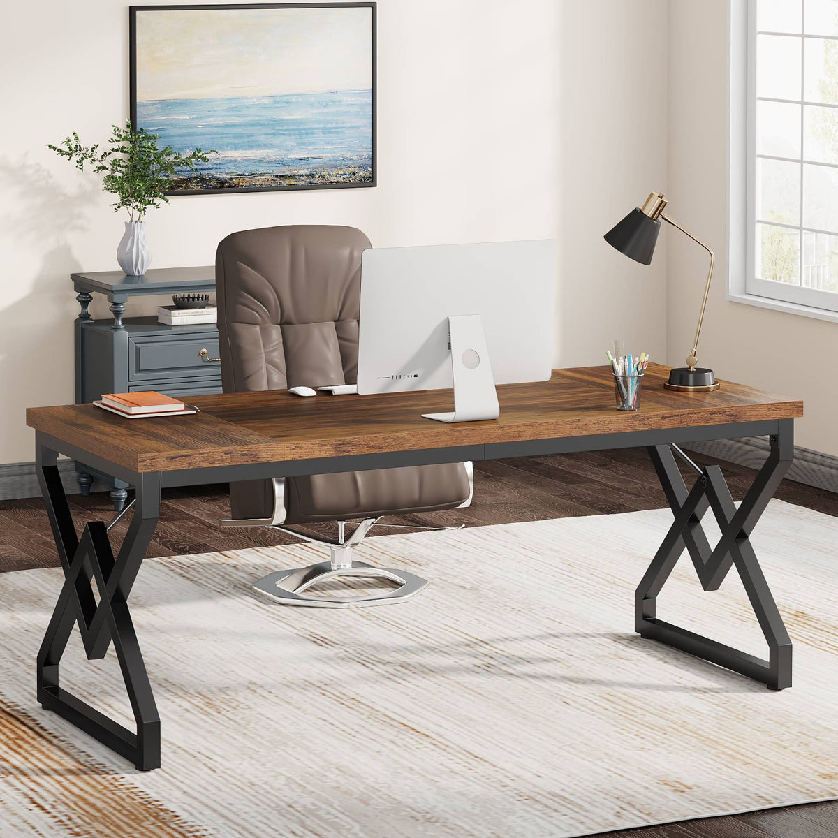 Executive desk with a desktop monitor, lamp and office chair by a filing cabinet