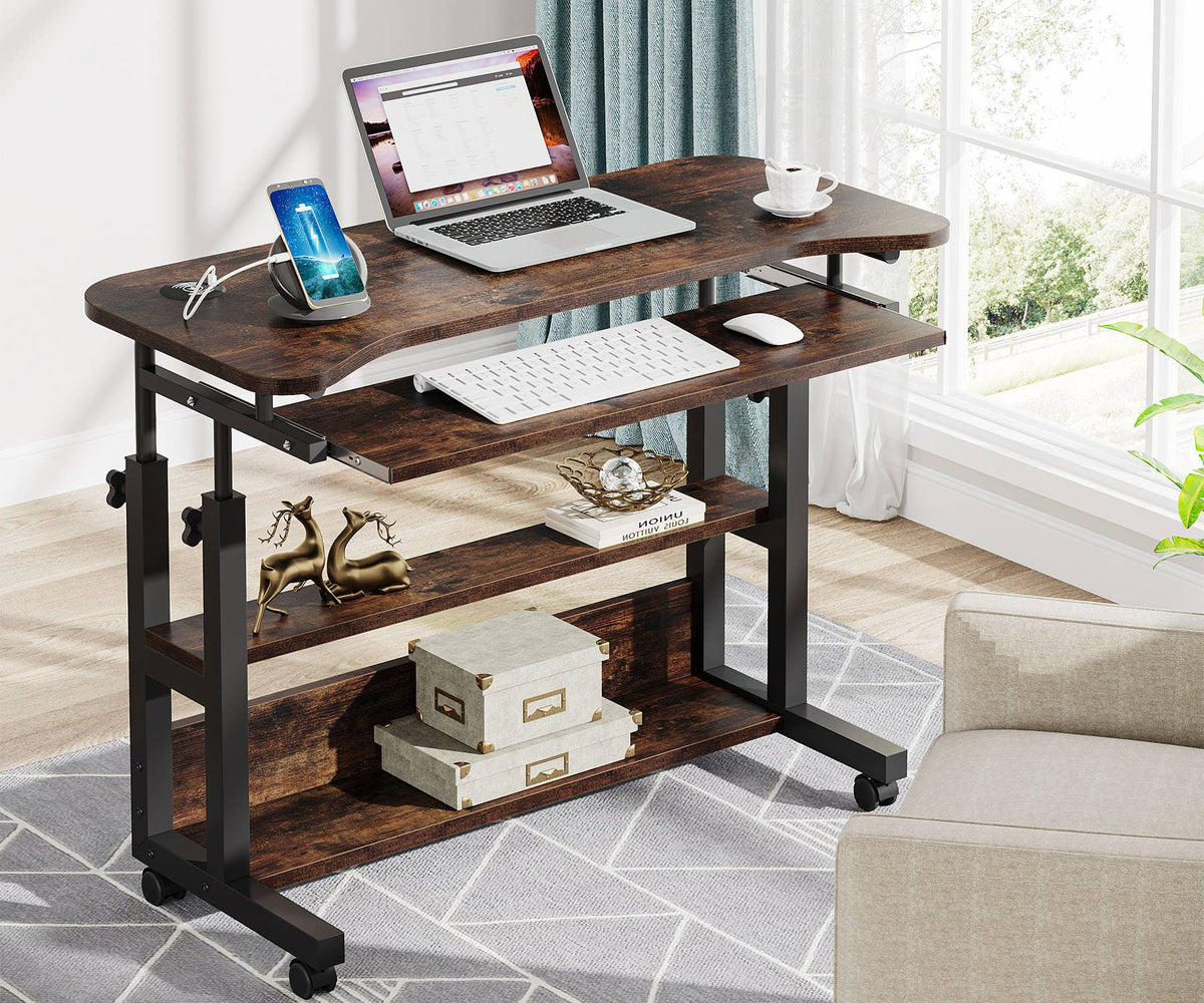 The desk at standing height with a laptop, phone on the charging pad and the keyboard tray out