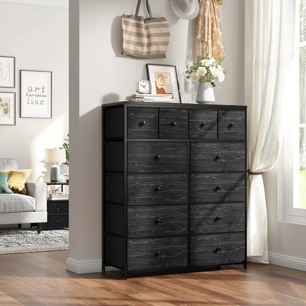 Black twelve drawer fabric dresser against a wall with a bag and photo frames on top