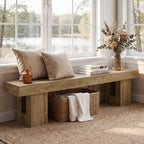 Long oak bench under a window with cushions and a basket beneath