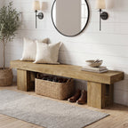 Oak entryway bench under a round mirror with boots stored below