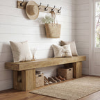 Oak bench below a row of wall hooks in a mudroom