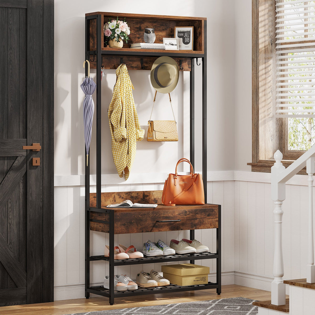 Rustic hall tree with hung jackets, bag on the seat and shoes below by a barn door