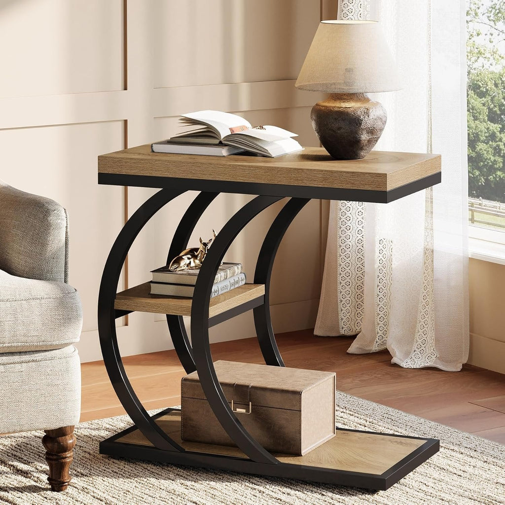 Rustic brown C shaped table beside an armchair with a lamp on top
