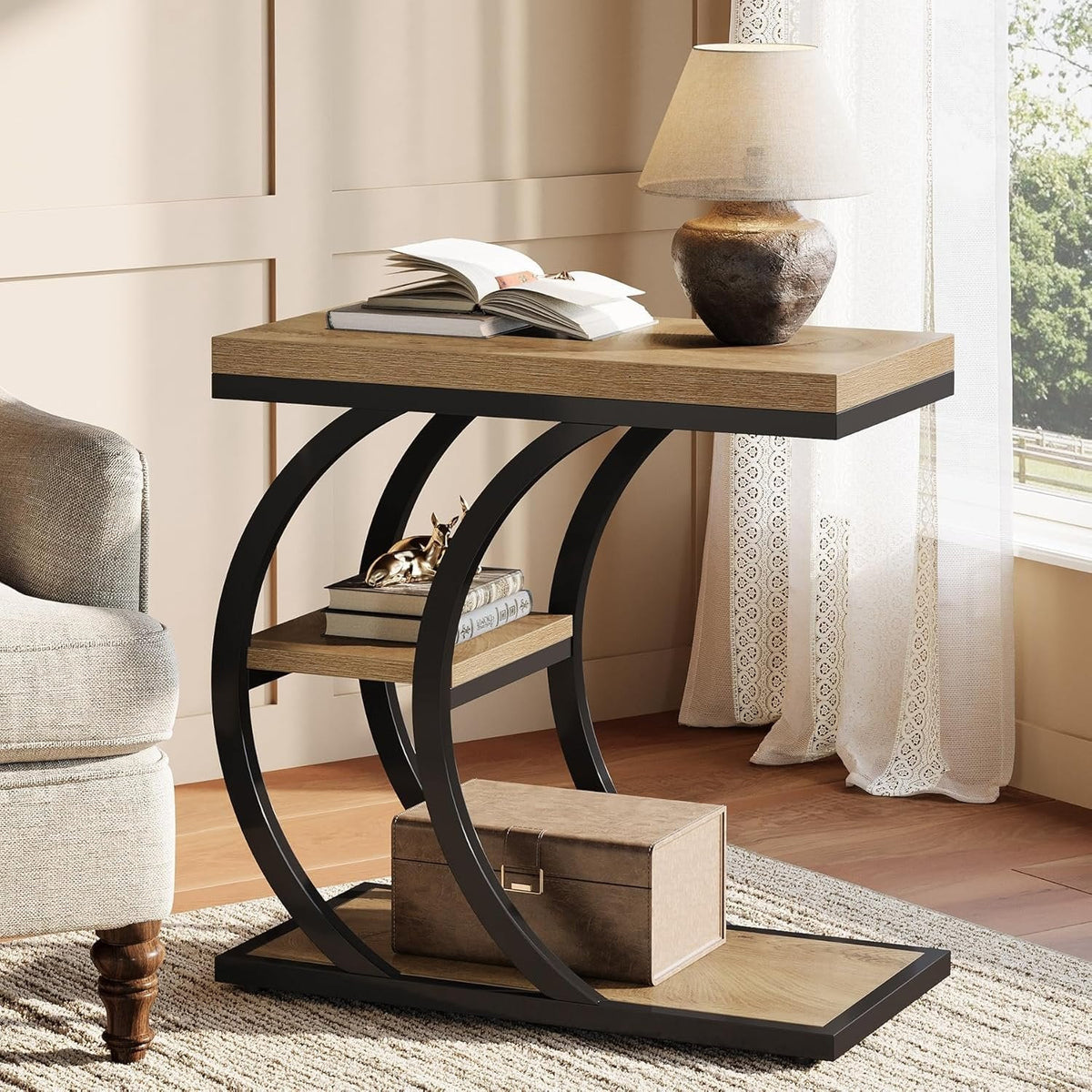Rustic brown C shaped table beside an armchair with a lamp on top