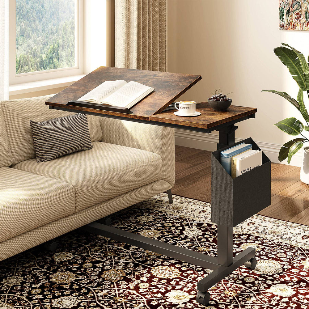 C table over a sofa with the tilting section holding an open book and a cup on the flat section
