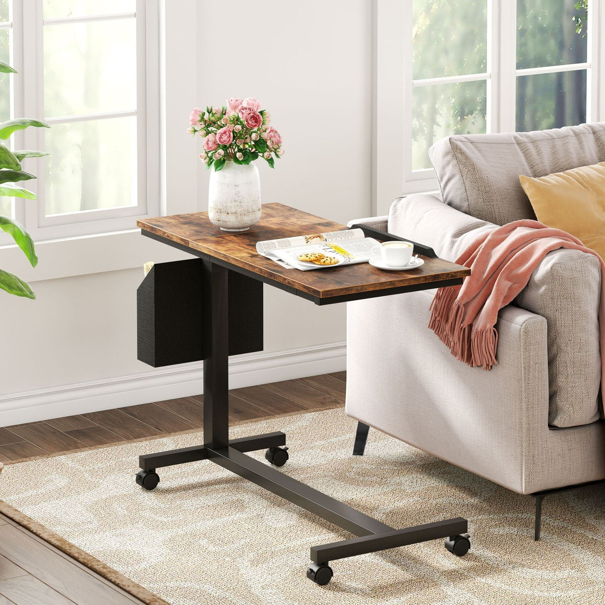 C table beside a sofa with the tabletop flat, holding a plate and a vase, blanket over the arm