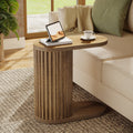 Stowena fluted C shaped end table with an oval top beside a sofa