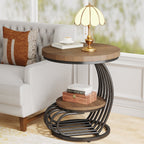 Round end table beside an armchair holding a lamp and books