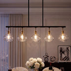 Five light linear chandelier with rippled glass shades lit above a dining table