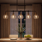 The five globes lit above a dining table at night