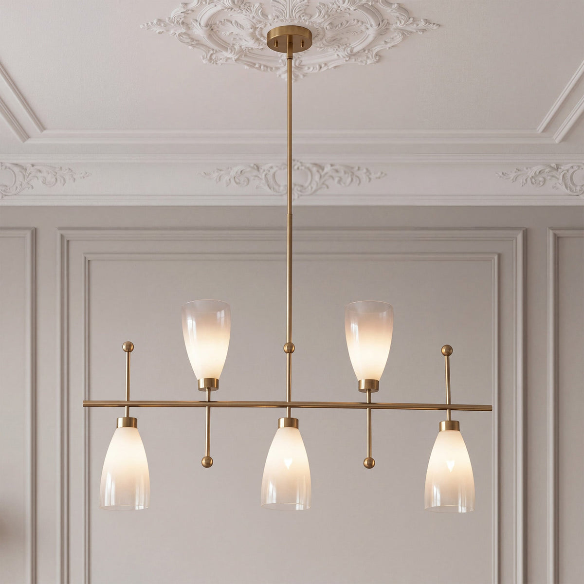 Five light brushed brass chandelier with gradient frosted glass shades below a ceiling rose