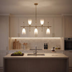 The fixture lit above a kitchen island in a cream shaker kitchen at night