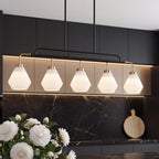 The frosted glass pendant hanging over a dining table set for breakfast