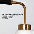 Close view of the brushed brass arm and collar meeting the frosted shade