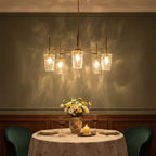The chandelier casting a soft water pattern shimmer on a green dining room wall