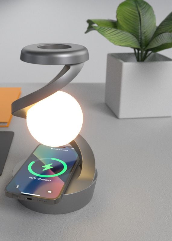 Gray rotating moon desk lamp charging a phone wirelessly on its base