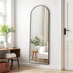 Arched full length mirror against a white wall beside a console table