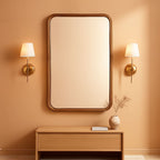 Stowena wood framed bathroom mirror 24 x 36 in hung above a console in a warm room