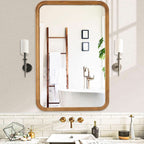 Wood framed rectangular mirror above a bathroom basin between two wall lights