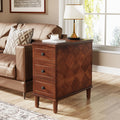 Stowena fully assembled 3 drawer nightstand in rustic brown beside a leather sofa