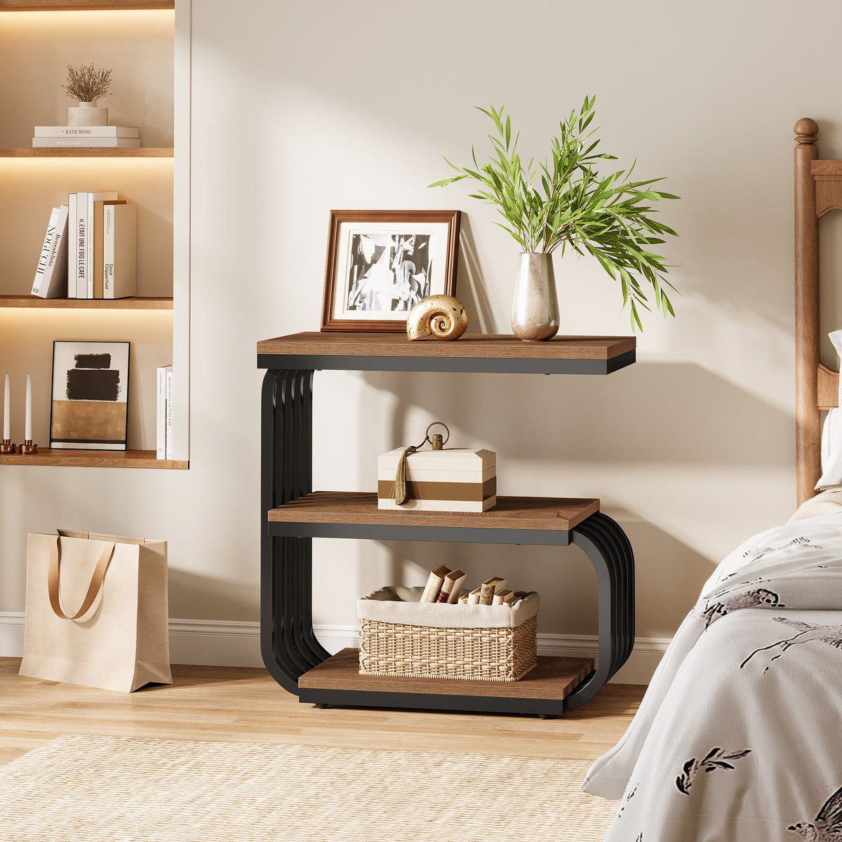 Narrow three tier nightstand against a wall with books and a plant
