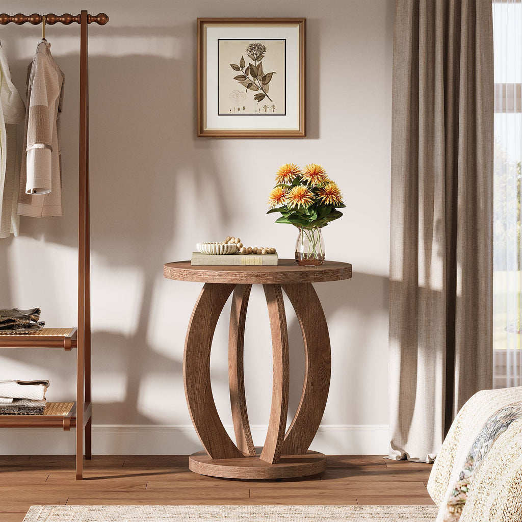 Round side table with flowers next to a clothes rack in a bedroom