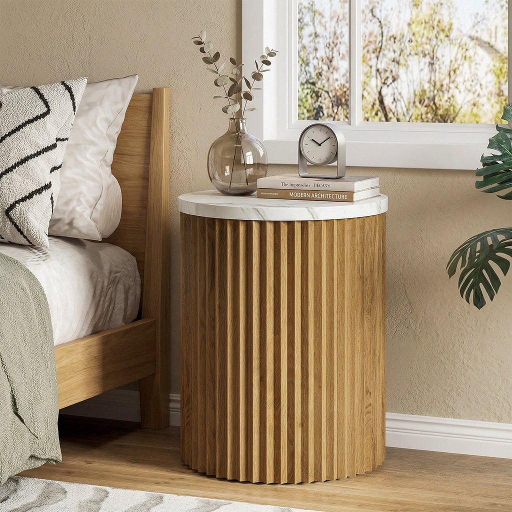 Stowena round fluted nightstand with faux marble top beside a wood bed