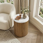 Fluted drum table beside a boucle armchair in a bright corner